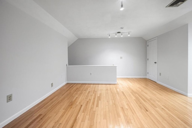 bonus room featuring visible vents, baseboards, light wood-style floors, and vaulted ceiling