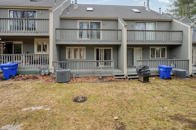 back of house with a balcony, cooling unit, and a yard