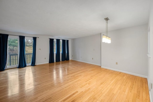 spare room featuring light wood-type flooring and baseboards