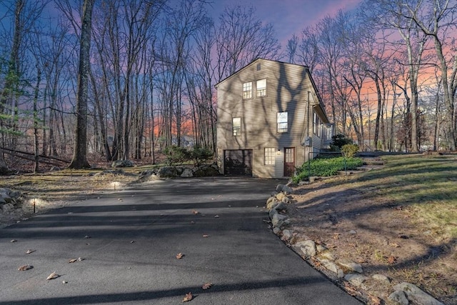 property exterior at dusk featuring a garage