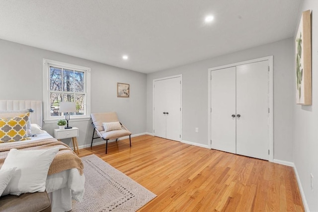 bedroom with two closets and hardwood / wood-style flooring