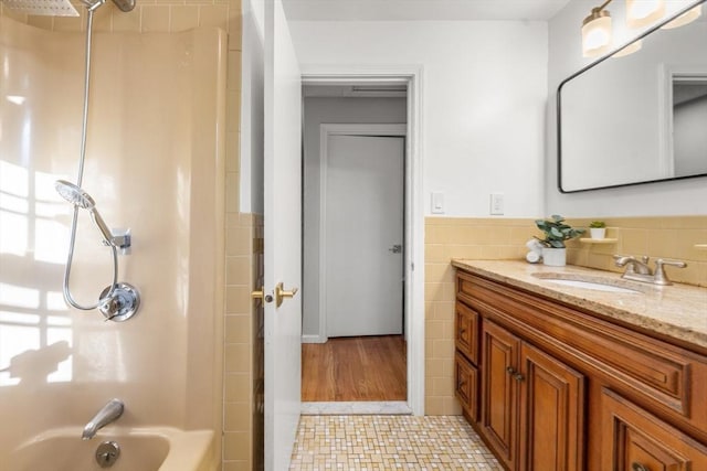 bathroom with vanity, tile patterned flooring, tile walls, and  shower combination