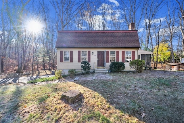 view of front facade featuring a sunroom and a front lawn