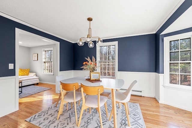 dining space with light hardwood / wood-style floors, a notable chandelier, and ornamental molding