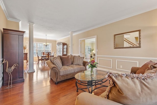 2 Rich Rd, Milford, MA 01757 - living area with wood finished floors, a wainscoted wall, a chandelier, ornamental molding, and ornate columns