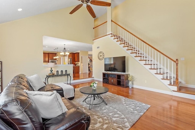 2 Rich Rd, Milford, MA 01757 - living room with high vaulted ceiling, ceiling fan with notable chandelier, stairs, and wood finished floors