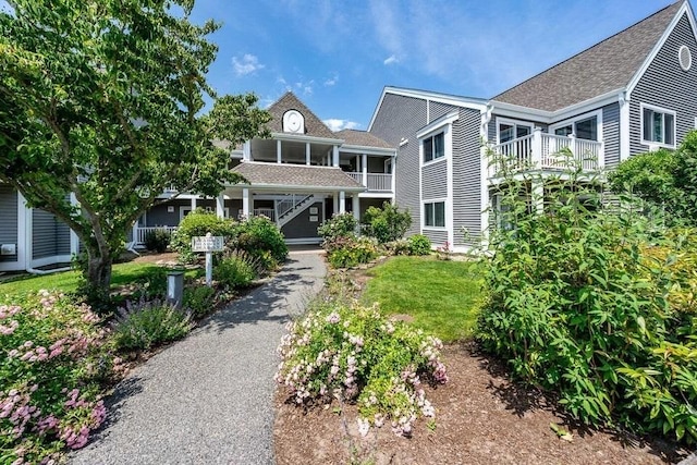 view of front of home featuring a balcony and a front yard