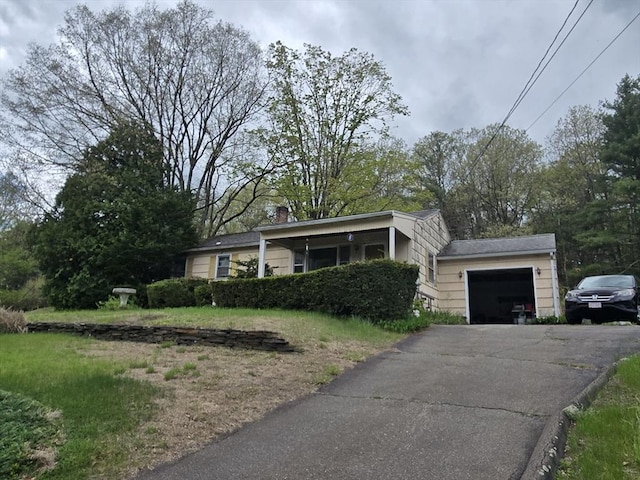 view of front facade with a garage, driveway, and a chimney