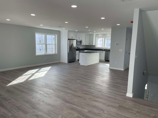 kitchen featuring hardwood / wood-style floors, stainless steel appliances, white cabinetry, and a healthy amount of sunlight