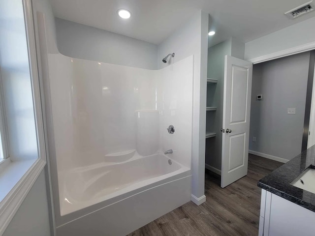 bathroom with hardwood / wood-style flooring, vanity, and  shower combination