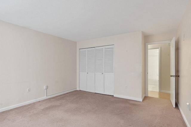 unfurnished bedroom with light carpet and a closet