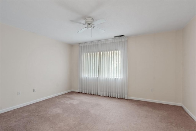 spare room with ceiling fan and light colored carpet