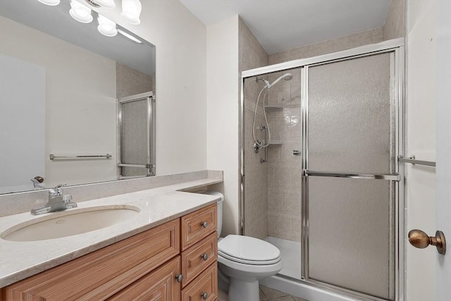 bathroom featuring tile patterned flooring, vanity, toilet, and an enclosed shower