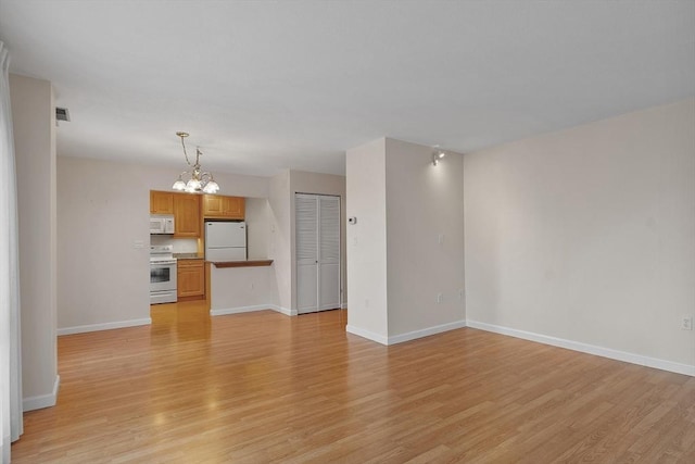 unfurnished living room featuring light hardwood / wood-style flooring and a chandelier