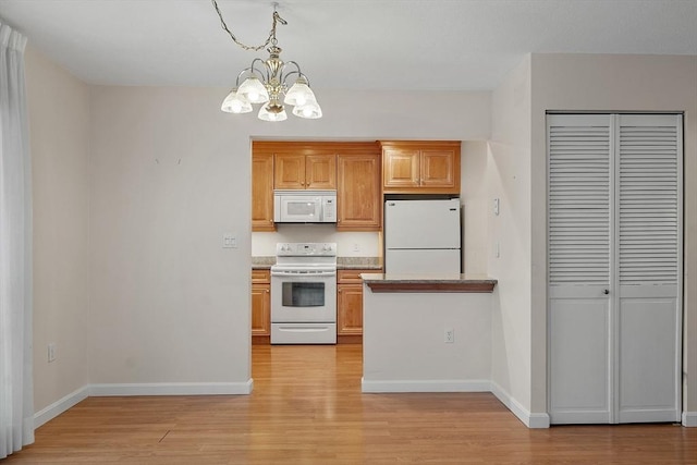 kitchen featuring decorative light fixtures, light hardwood / wood-style flooring, a chandelier, and white appliances