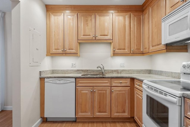 kitchen with light stone countertops, white appliances, sink, and light hardwood / wood-style flooring