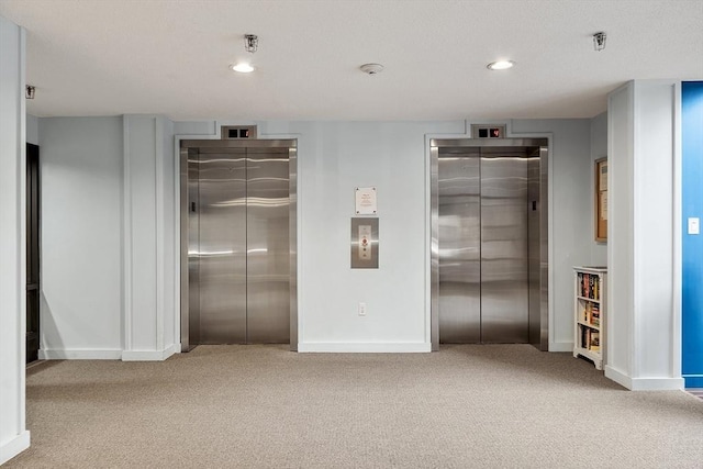 interior space featuring light carpet, elevator, and a closet