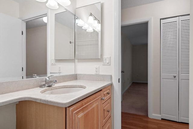 bathroom featuring hardwood / wood-style floors, vanity, and a textured ceiling