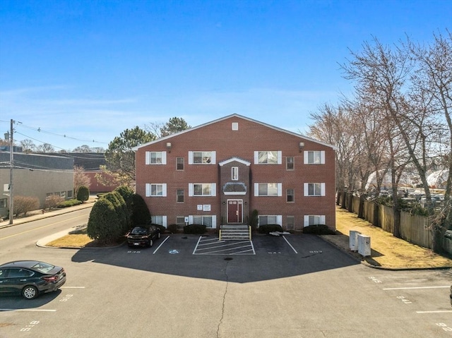 view of property with uncovered parking and fence