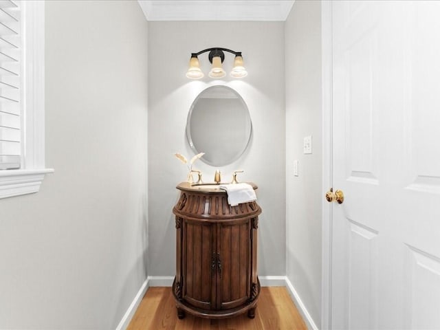 bathroom with vanity, ornamental molding, and hardwood / wood-style floors