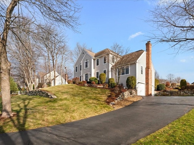 view of side of property with a garage and a lawn