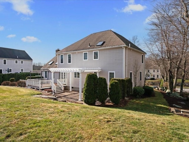 back of house featuring a wooden deck, a lawn, and a pergola