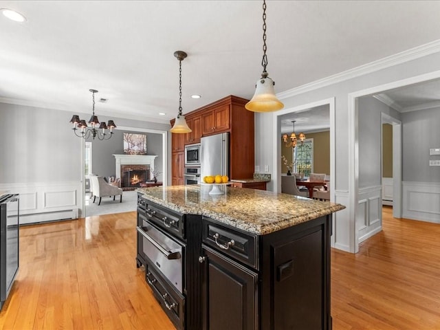 kitchen featuring stainless steel appliances, a kitchen island, a chandelier, and decorative light fixtures