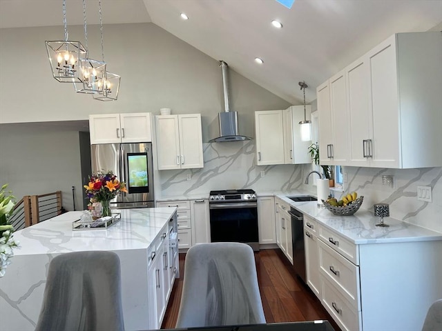 kitchen with light stone counters, white cabinets, stainless steel appliances, and a sink