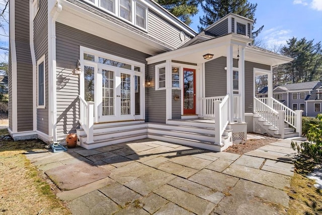 entrance to property with a porch and french doors