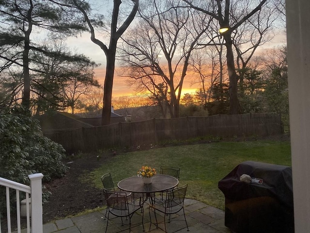 view of yard featuring outdoor dining area, a patio area, and fence