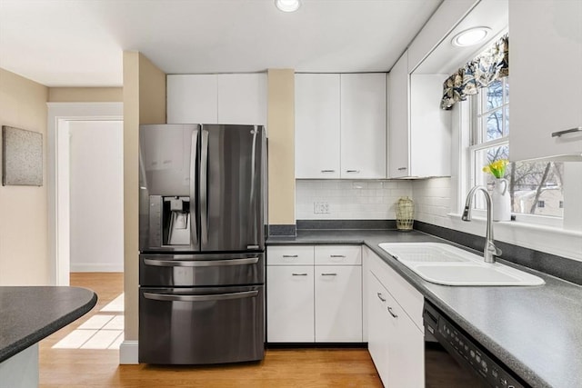 kitchen with light wood finished floors, white cabinets, a sink, dishwasher, and stainless steel fridge with ice dispenser