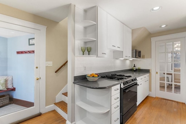 kitchen with dark countertops, light wood-type flooring, black range with gas stovetop, and open shelves