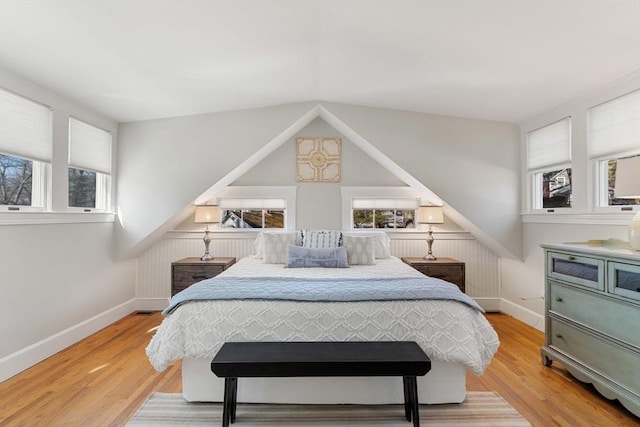 bedroom with multiple windows, baseboards, and wood finished floors