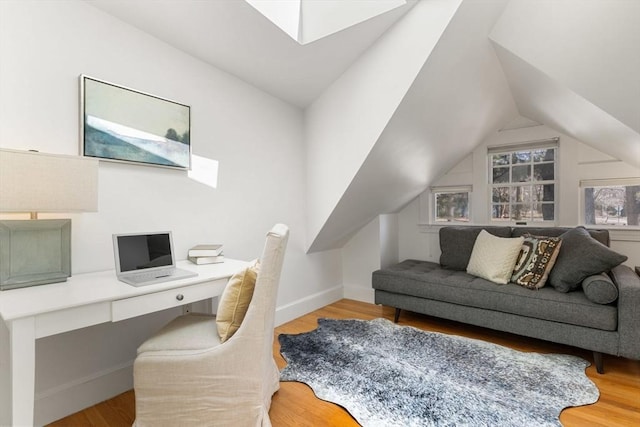 home office with lofted ceiling, wood finished floors, built in study area, and baseboards