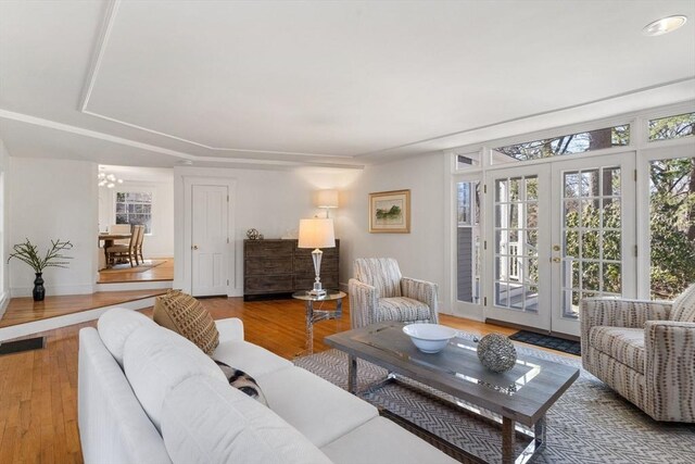 living area featuring french doors, baseboards, and wood finished floors