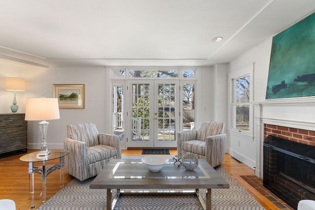 living area with light wood finished floors, a fireplace, and baseboards