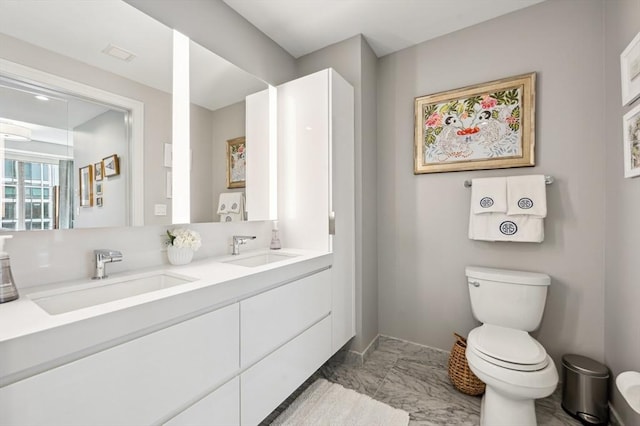 133 Seaport Blvd Unit 823, Boston, MA 02210 - bathroom with toilet, double vanity, marble look tiles, and baseboards