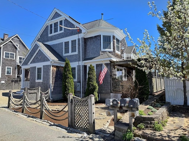 view of front of property featuring fence and roof with shingles