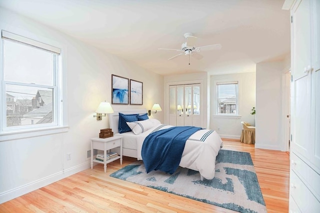 bedroom featuring baseboards, light wood-style flooring, and ceiling fan