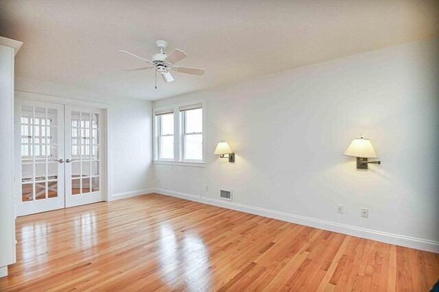 spare room with baseboards, visible vents, french doors, and wood finished floors