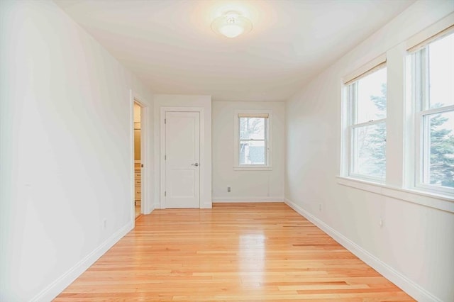 empty room featuring baseboards and light wood-style flooring