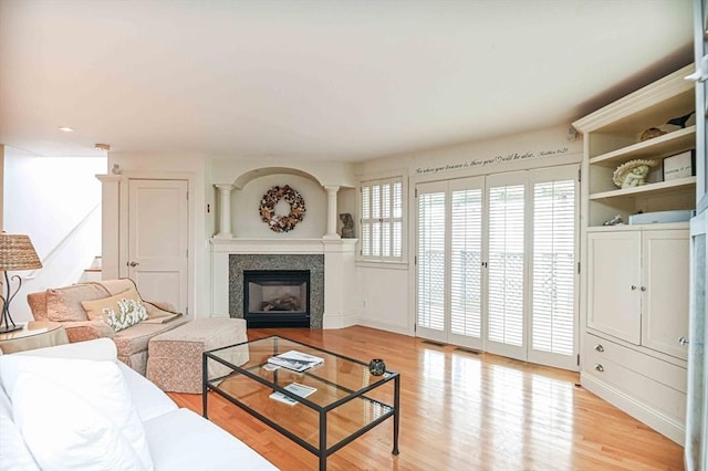 living area featuring visible vents, a fireplace, light wood-type flooring, baseboards, and recessed lighting