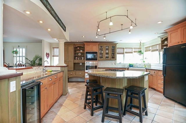 kitchen featuring a breakfast bar area, a center island, open shelves, black appliances, and beverage cooler
