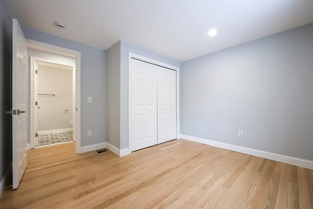 44 Dean Rd, Wayland, MA 01778 - unfurnished bedroom with light wood-type flooring, baseboards, and a closet