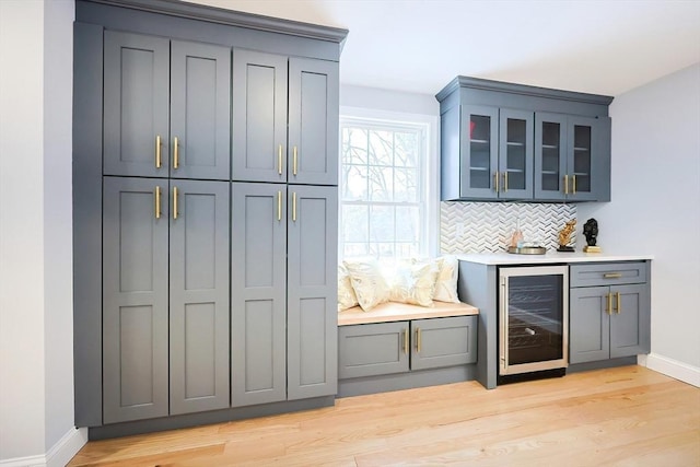 44 Dean Rd, Wayland, MA 01778 - indoor dry bar with beverage cooler, baseboards, decorative backsplash, and light wood finished floors