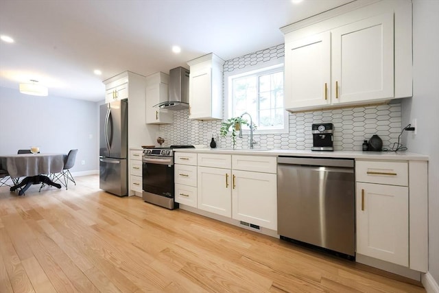 44 Dean Rd, Wayland, MA 01778 - kitchen featuring stainless steel appliances, wall chimney exhaust hood, a sink, light countertops, and backsplash