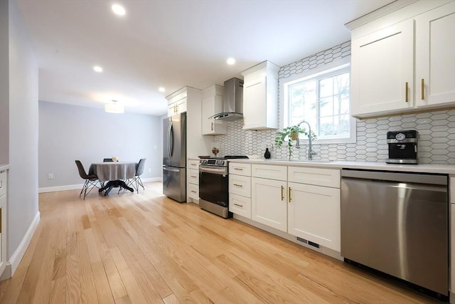 44 Dean Rd, Wayland, MA 01778 - kitchen with stainless steel appliances, wall chimney exhaust hood, a sink, light countertops, and recessed lighting