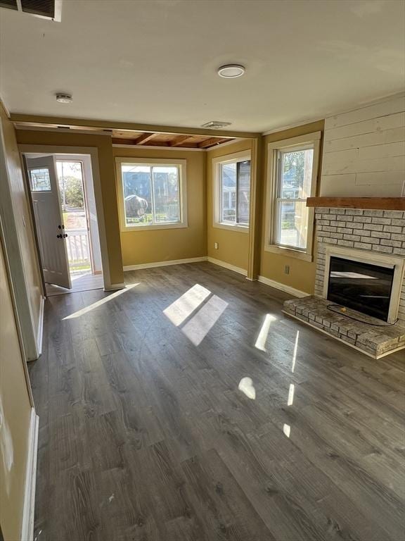 83 Shore Ave, Wareham, MA 02571 - unfurnished living room featuring a brick fireplace, dark wood-style flooring, baseboards, and plenty of natural light