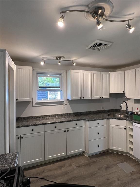 83 Shore Ave, Wareham, MA 02571 - kitchen with a sink, dark wood finished floors, white cabinetry, and dark stone counters