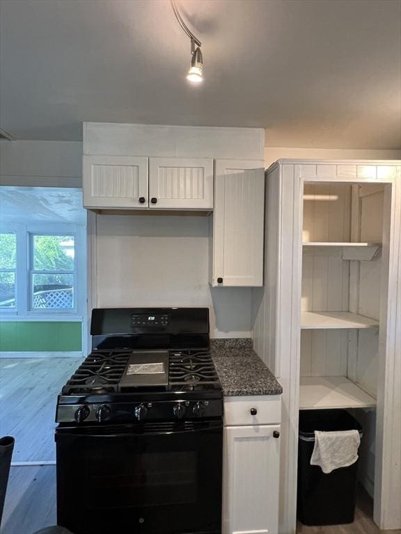 83 Shore Ave, Wareham, MA 02571 - kitchen with black range with gas stovetop, white cabinetry, wood finished floors, and dark stone counters